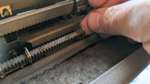 Hand removing the tab clip on a typewriter