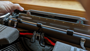 Opening the carriage back panel on a typewriter
